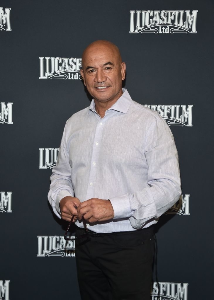 Man in semi-formal attire posing in front of a Lucasfilm backdrop