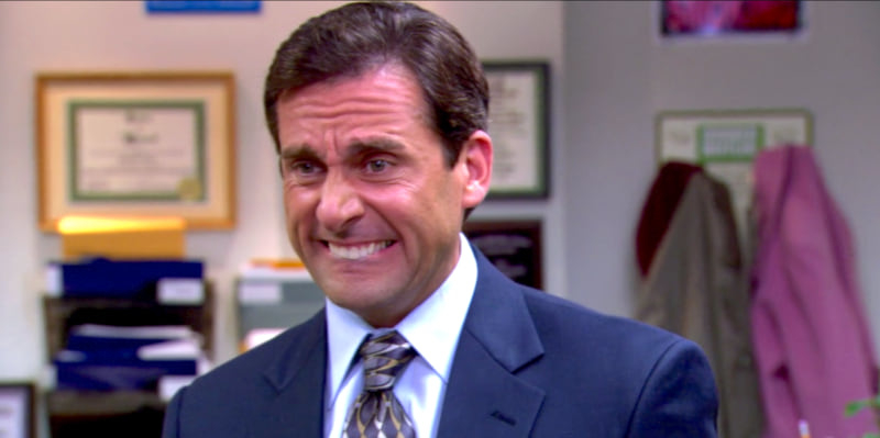 Man in a suit with a forced smile in an office setting