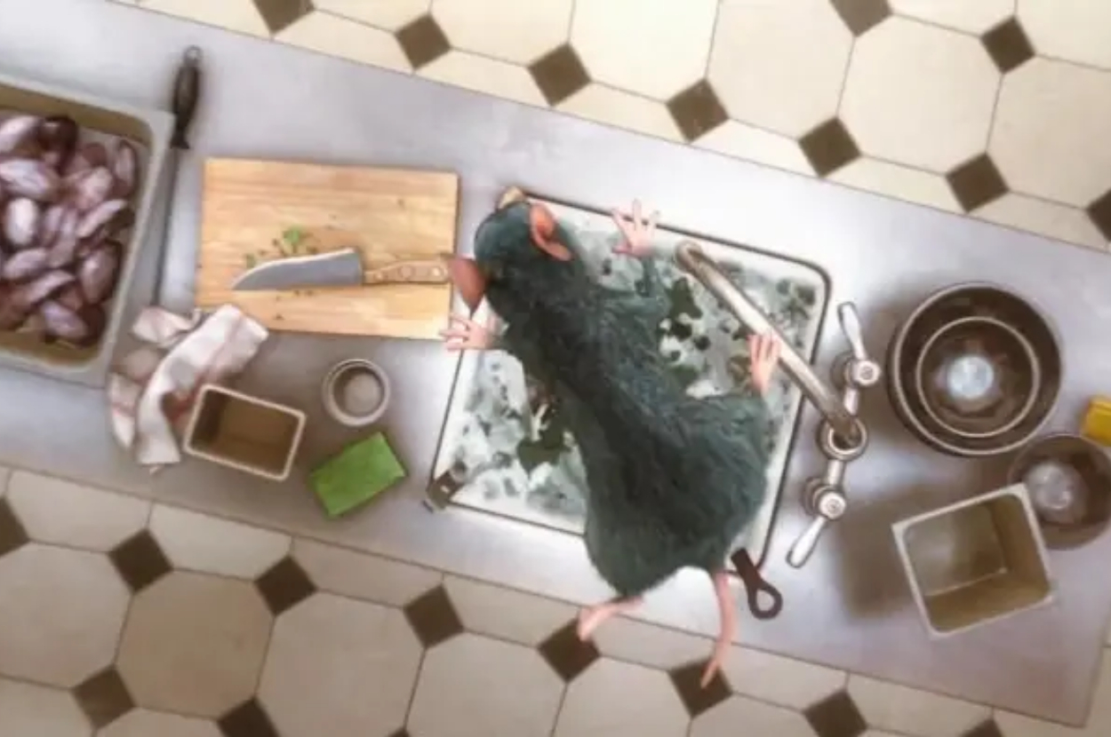 Animated character Remy from &quot;Ratatouille&quot; washing dishes at a kitchen sink, viewed from above