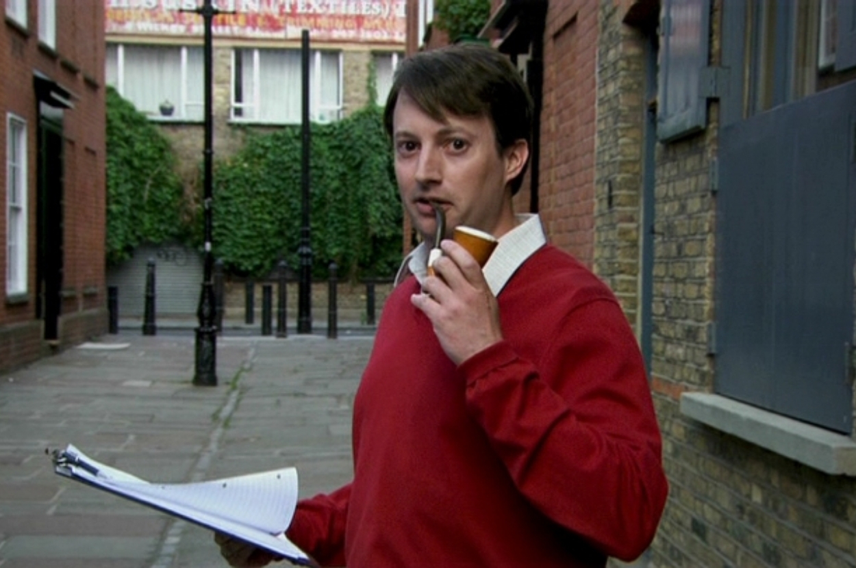 Man holding papers and talking on a cell phone on a city street