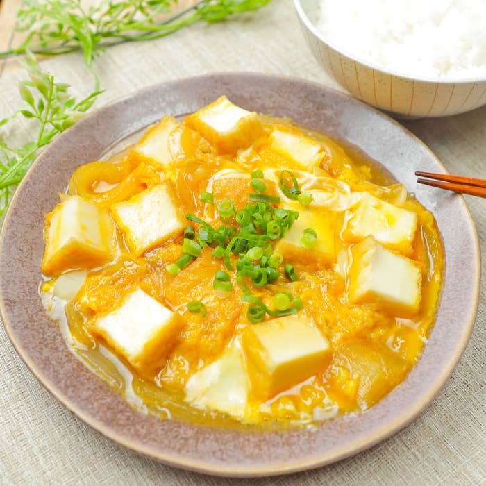 器に入った厚揚げと卵の和風料理、添え付けのご飯と箸も写っています。