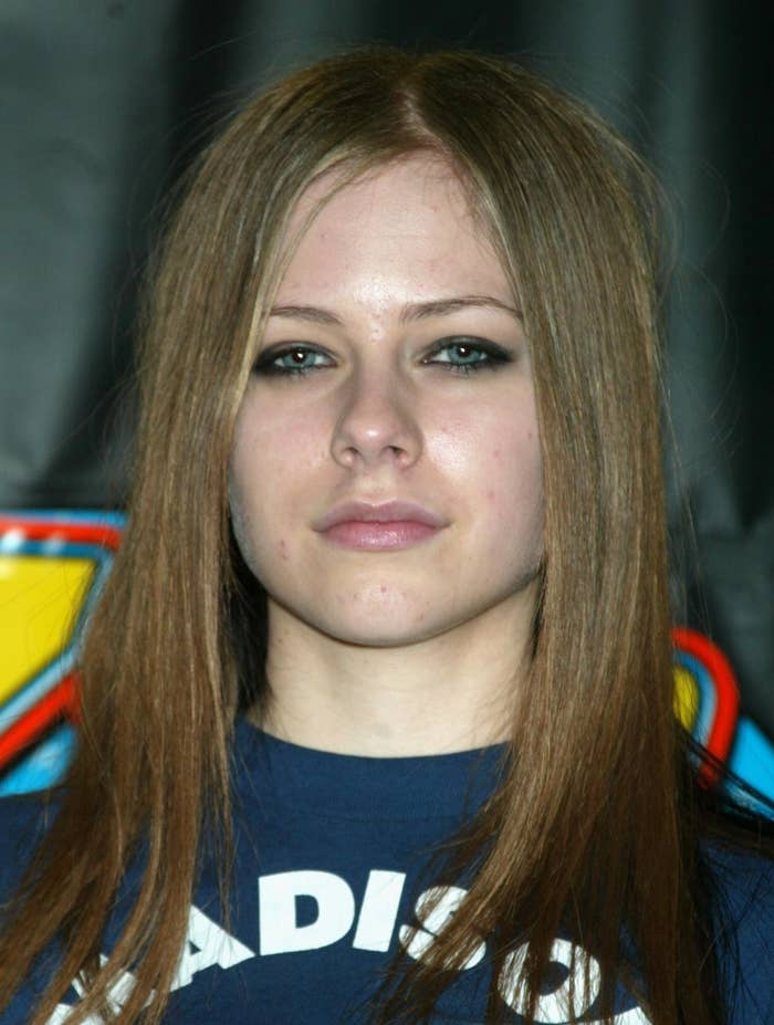 A younger Avril Lavigne in graphic tee posing for a photo
