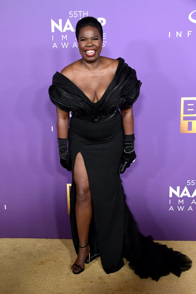 Leslie on a red carpet in an evening gown with a plunging neckline and high leg slit, wearing gloves