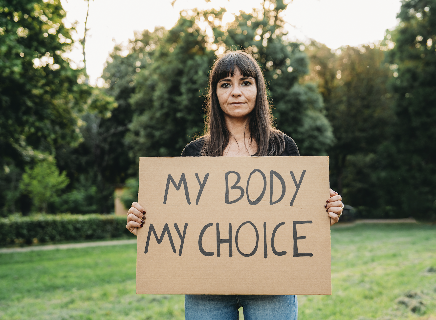 Woman holding a sign that reads "MY BODY MY CHOICE" at an outdoor rally