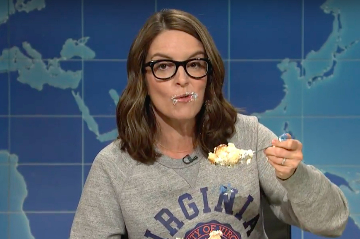 Tina Fey as character on SNL Weekend Update, eating cake and making a funny face