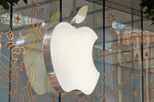 Apple logo on a store facade with artistic line patterns in the background