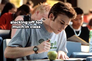 Chris Evans sitting at a desk with papers and a green apple, text: "slacking off too much in class"