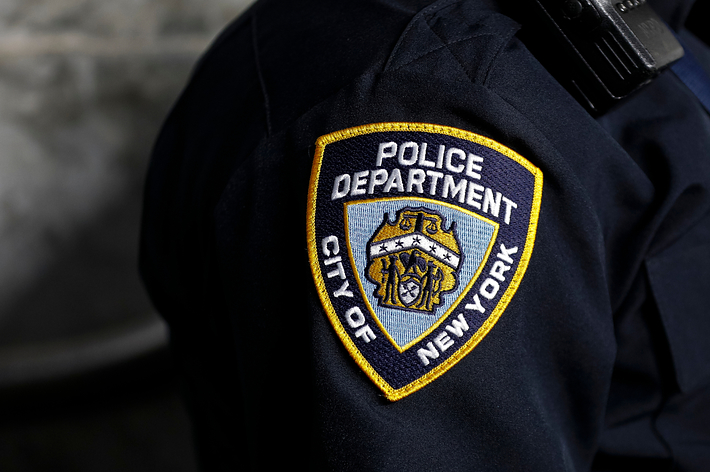 Close-up of an NYPD uniform shoulder patch on an officer, representing law enforcement in New York City