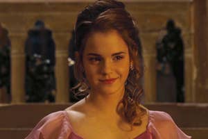Hermione Granger smiling in a pink Yule Ball gown from "Harry Potter."