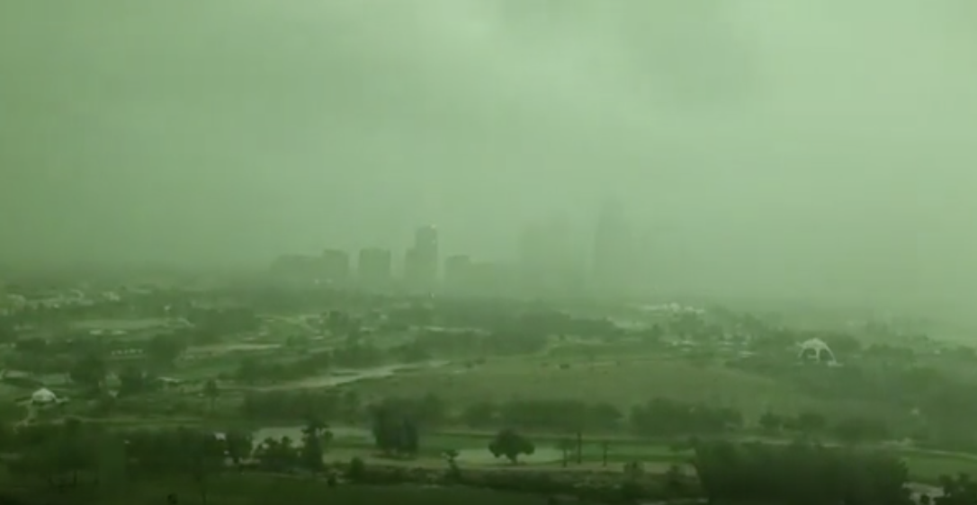 Cityscape shrouded in a haze, possibly indicating weather conditions or pollution, with visible structures and vegetation