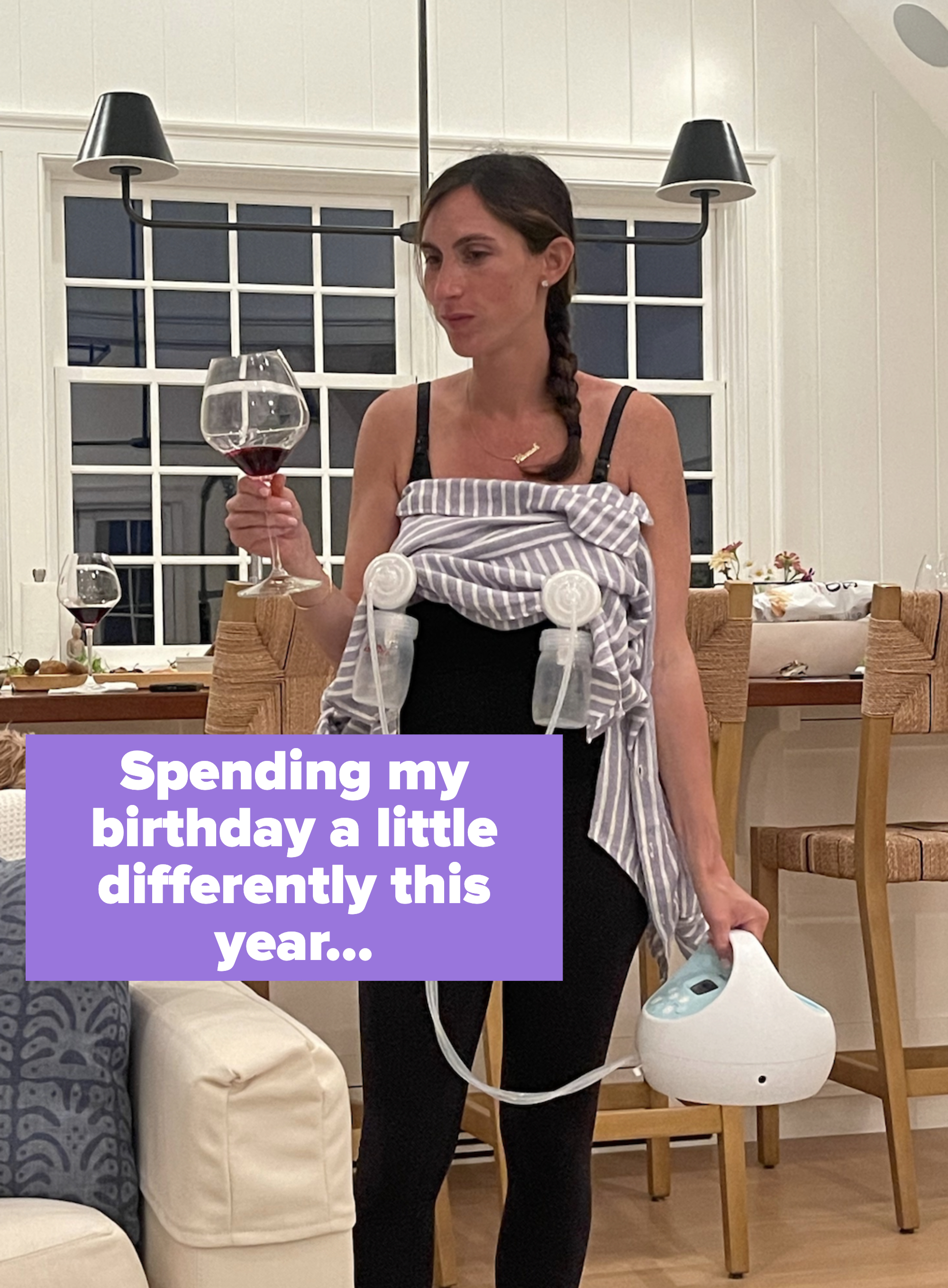 Woman in a striped top using a breast pump and holding a wine glass