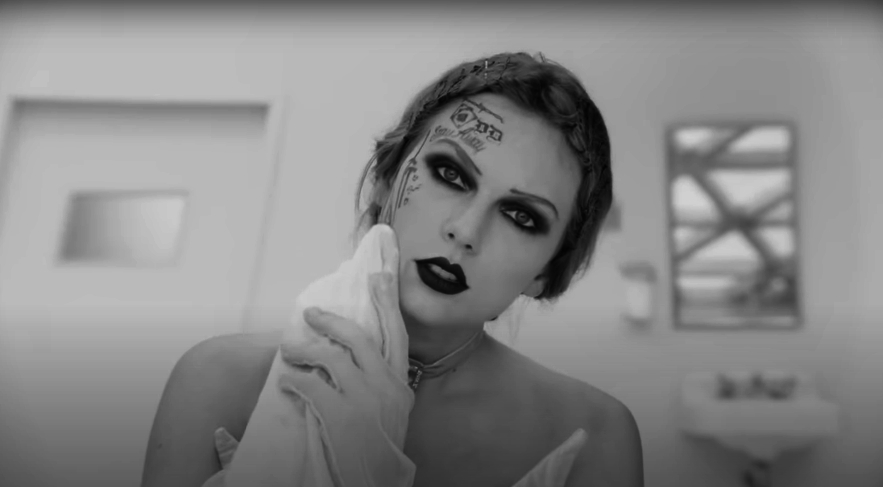 Taylor Swift with dramatic makeup and temporary face tattoos, wearing a choker, posing with a handkerchief