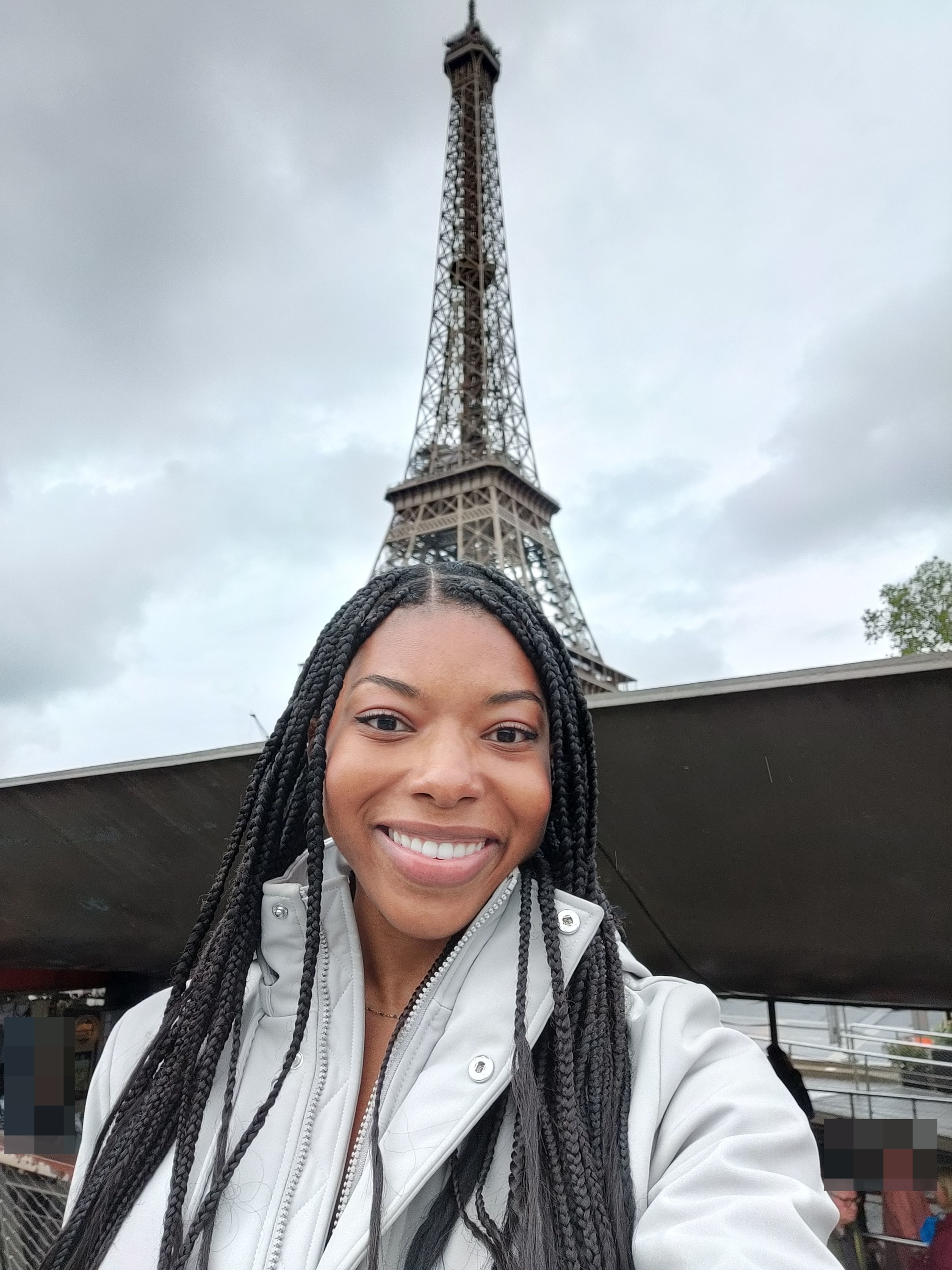 The author smiles for a selfie with the Eiffel Tower in the background