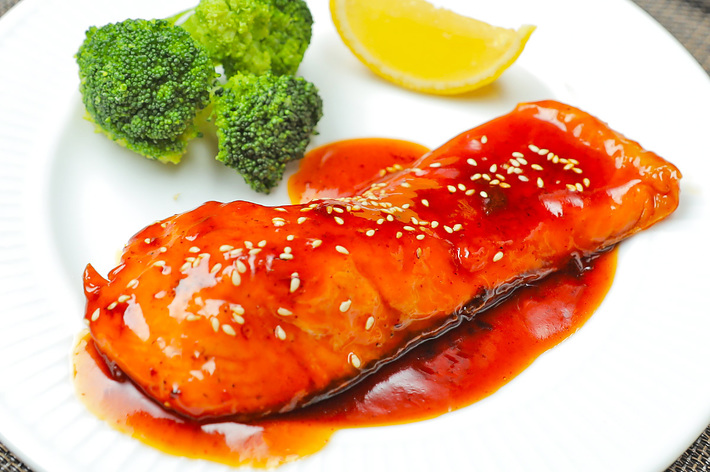 鶏の照り焼き、ブロッコリー、レモンのスライスが乗った皿。