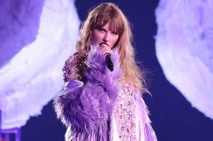 Taylor Swift performing on stage in a feathered outfit
