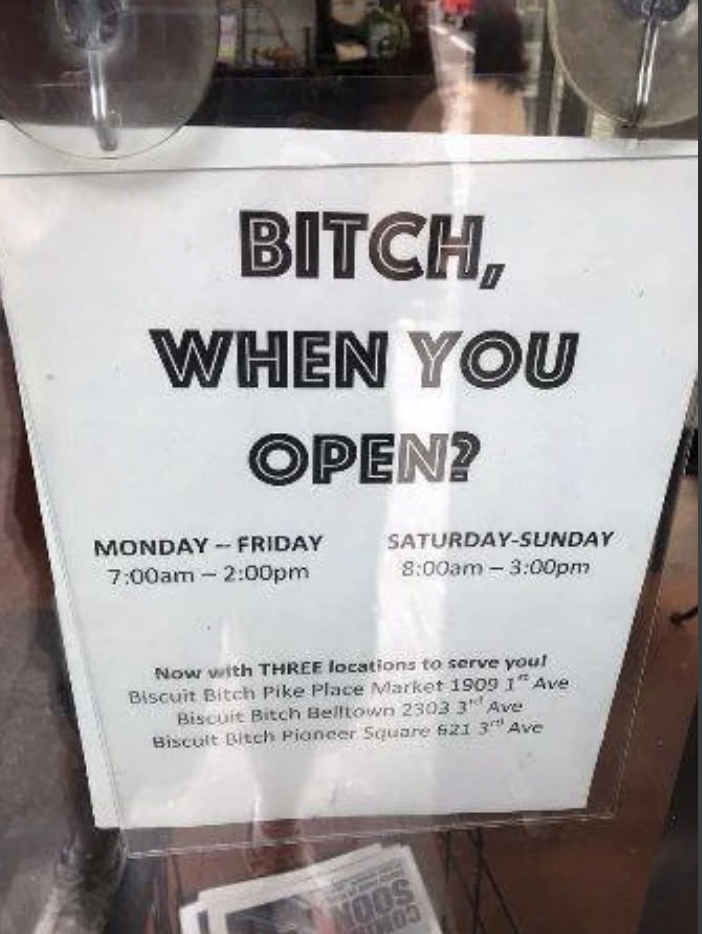 Signage with humorous tone lists business hours and locations for &#x27;Biscuit Bitch&#x27; café