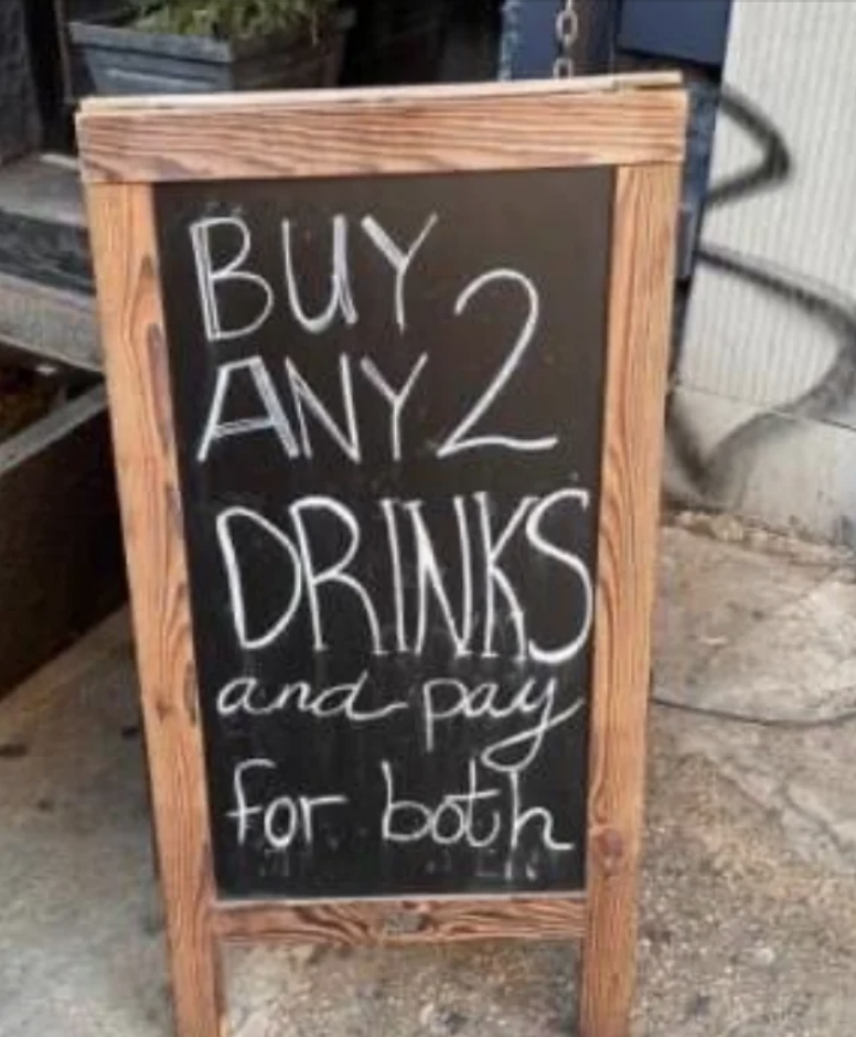Signboard offering a deal: &quot;Buy any 2 drinks and pay for both.&quot;