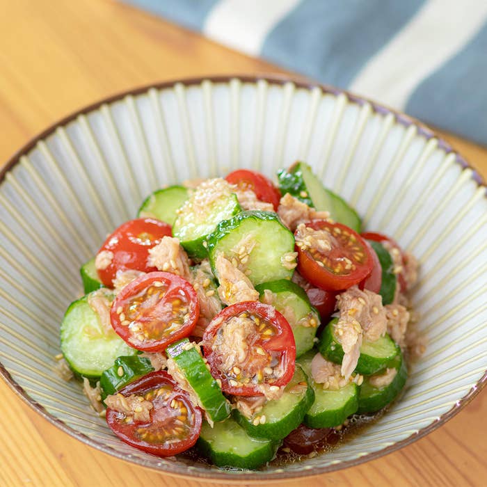 きゅうりとトマトのサラダにツナがトッピングされている写真です。