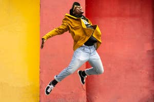 人がジャンプしている瞬間、黄色いジャケットとジーンズを着用。