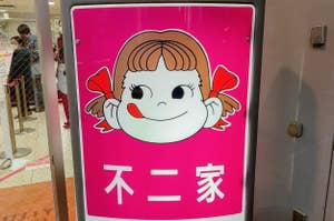 看板には漫画風の女の子の顔と「不二家」と書かれています。