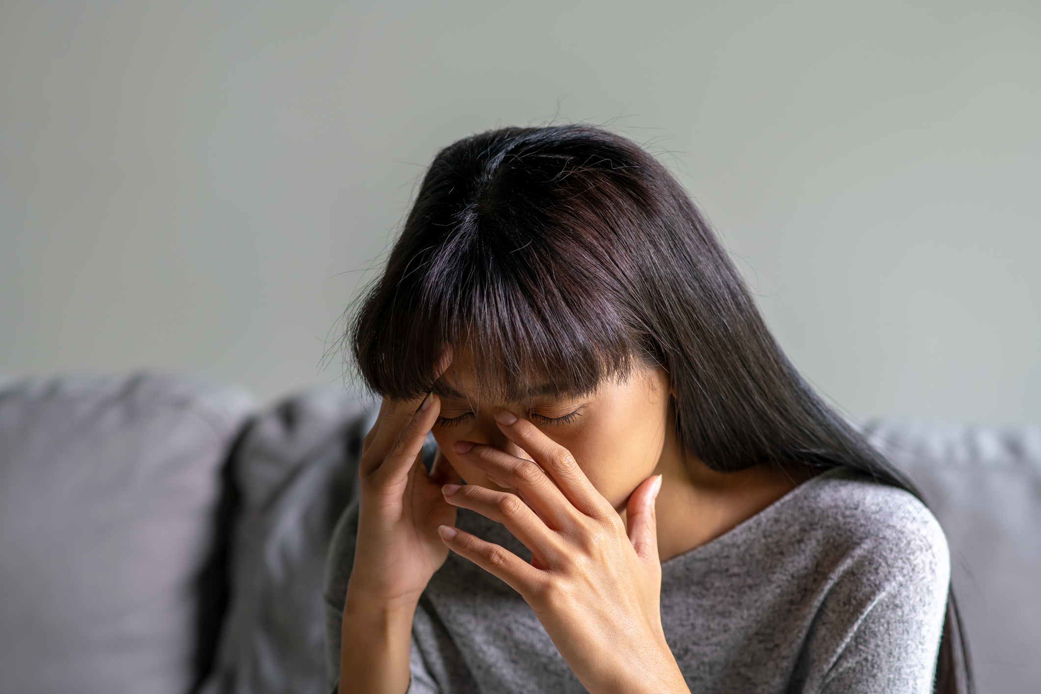 Person holding forehead appearing stressed or fatigued, possibly related to work or financial concerns