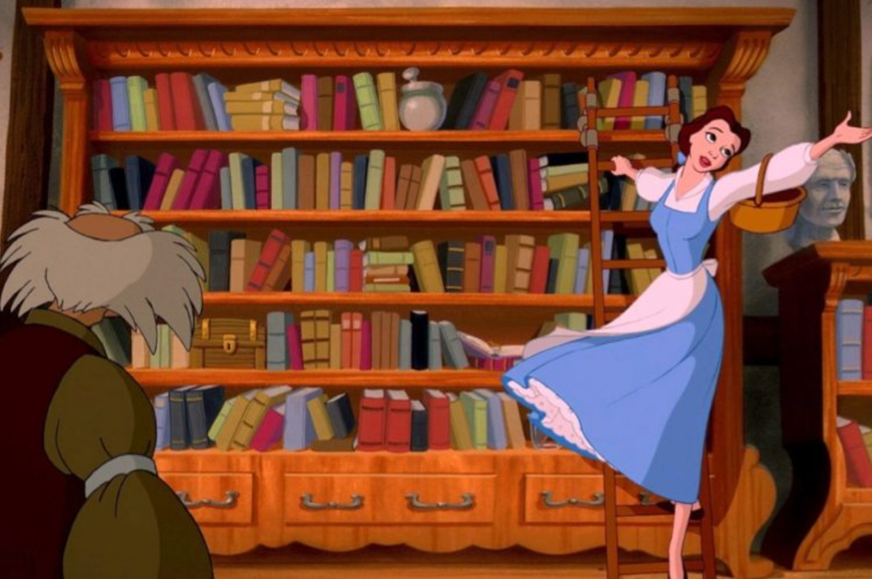Belle from Beauty and the Beast gestures excitedly in a library