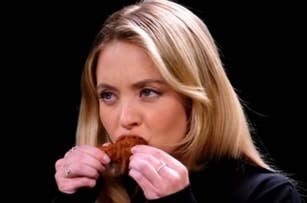 Woman tasting fried chicken, expressing focused culinary evaluation for an article in the Food category