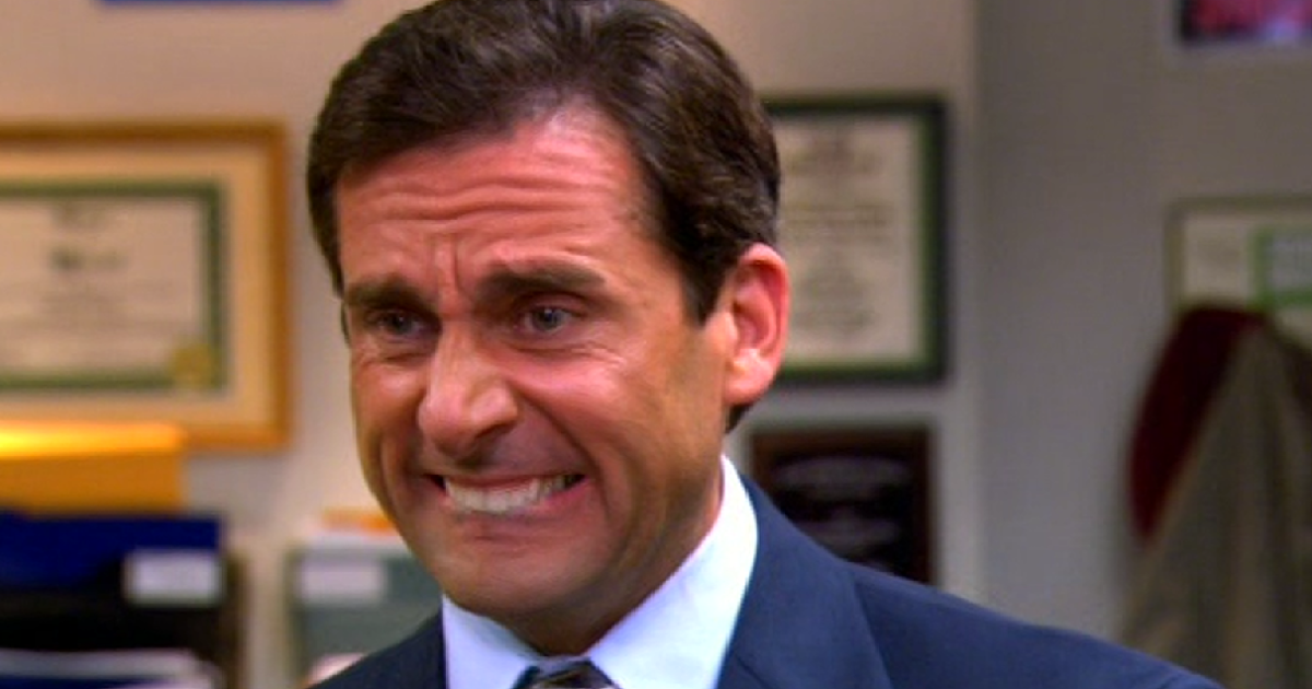 Character from TV show smirking in an office setting