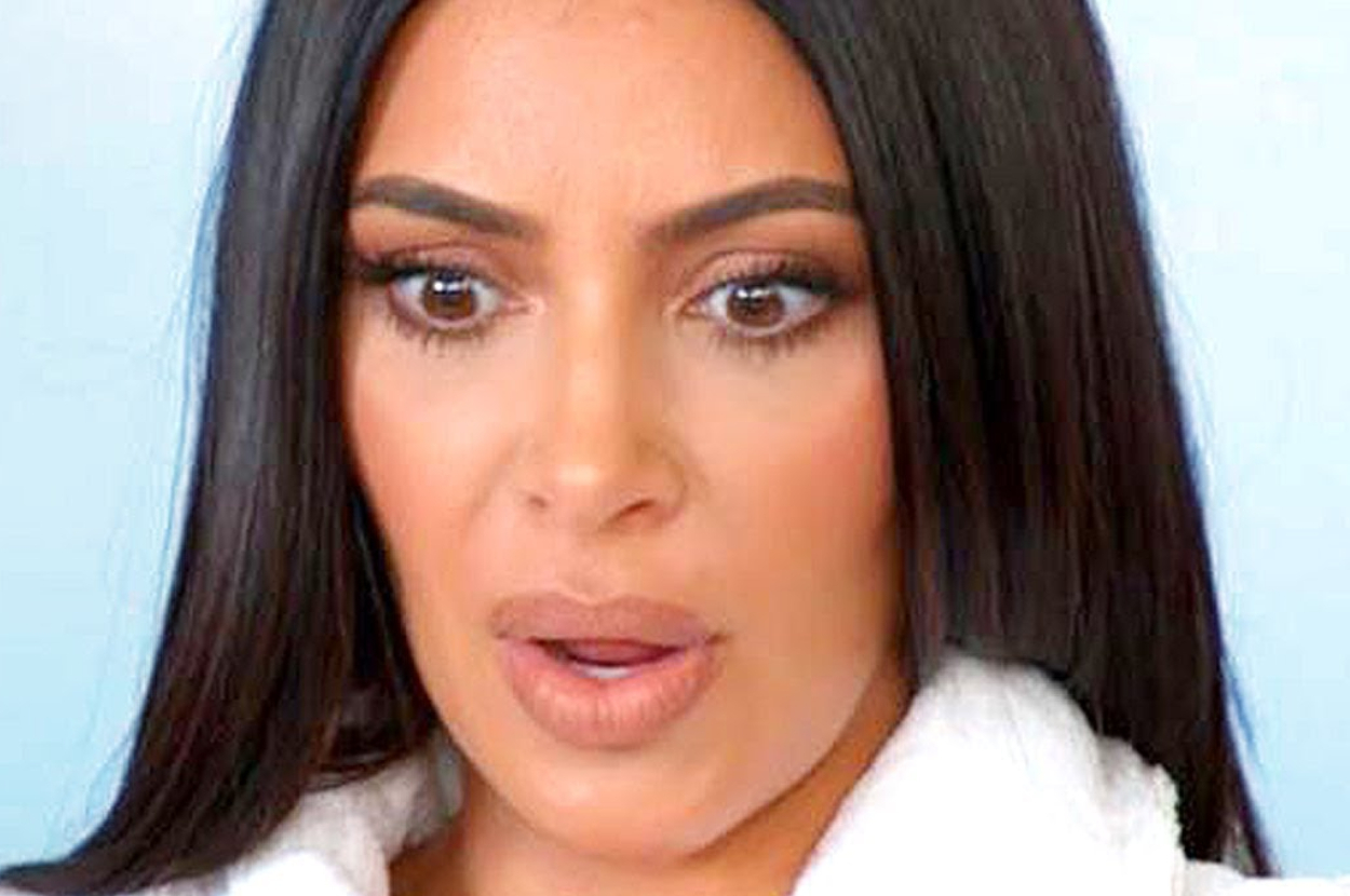 Kim Kardashian looking surprised with wide eyes and slightly parted lips, dressed in a white textured garment