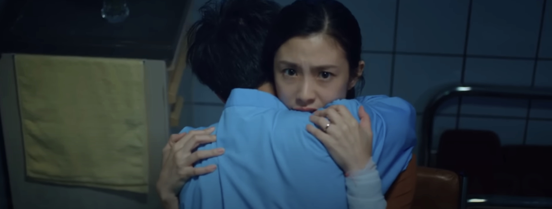 A scared woman embraces a man