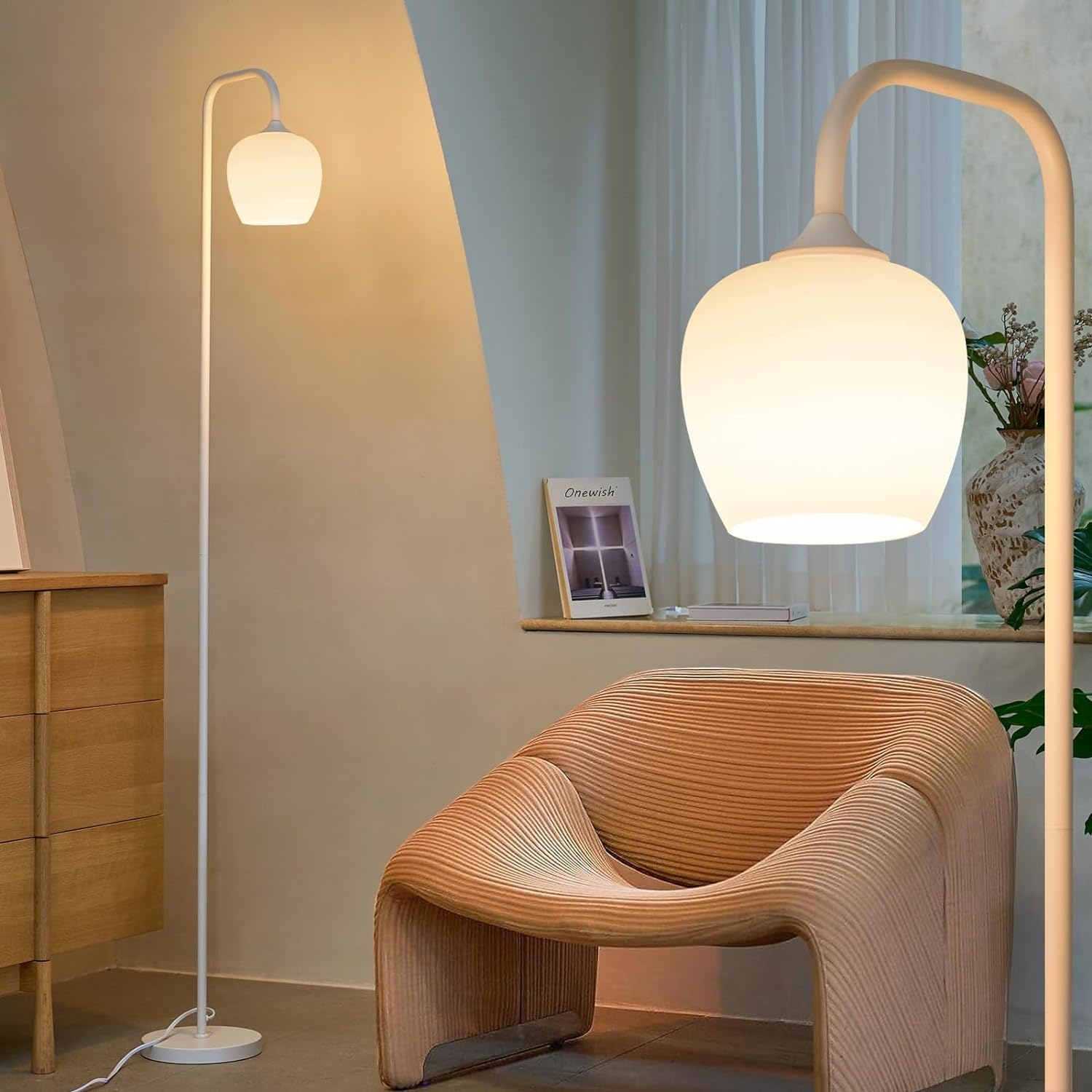 A modern floor lamp beside a wooden desk and a wavy-designed chair