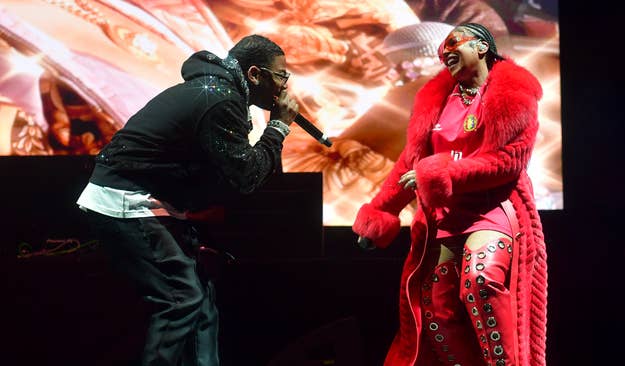 Two performers on stage, one in a red outfit with faux fur details, the other in black attire