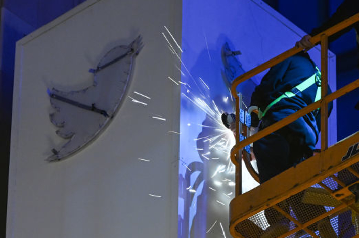 2023年7月29日、米国カリフォルニア州サンフランシスコのツイッター本社ビル屋上で、金曜の夜に「X」サインが設置され、青い鳥と文字を外す作業員たち（Anadolu / Anadolu Agency via Getty Images）