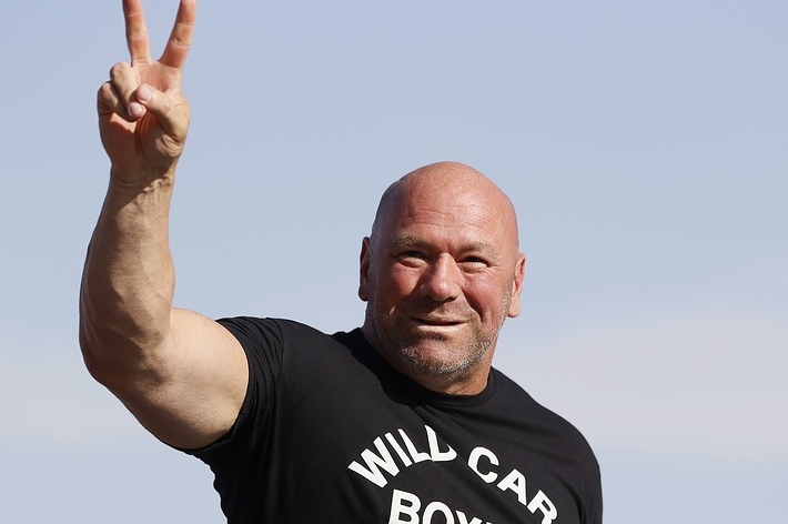 Dana White, wearing a "Will Car Boys" T-shirt, smiling and making a peace sign gesture