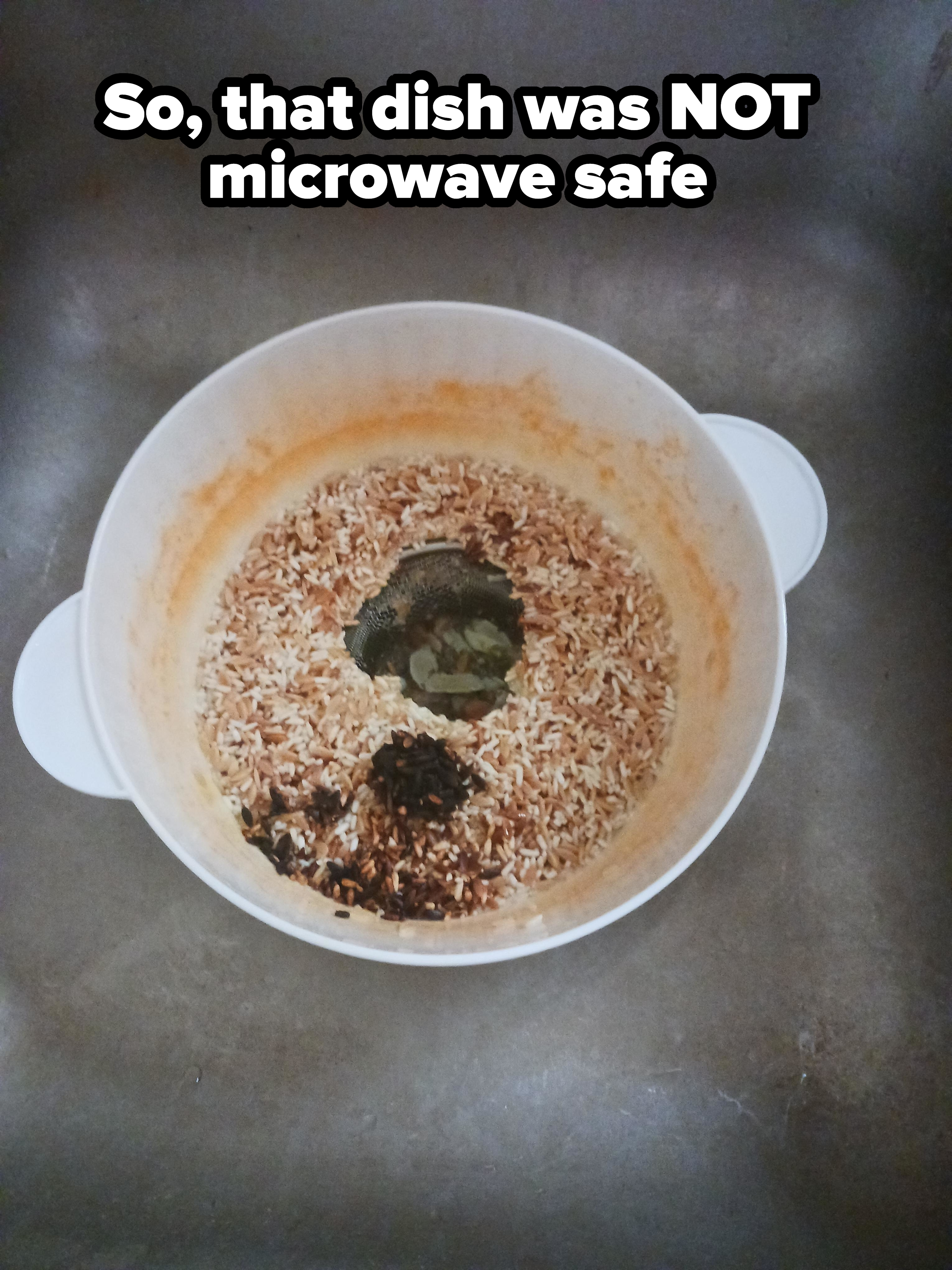 A plastic rice cooker with burnt rice residue at the bottom is placed in a sink