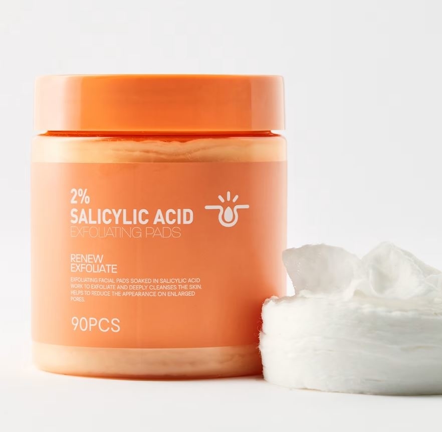 Tub of 2% salicylic acid exfoliating pads with the label stating &quot;Renew Exfoliate.&quot; Pads are shown next to the tub