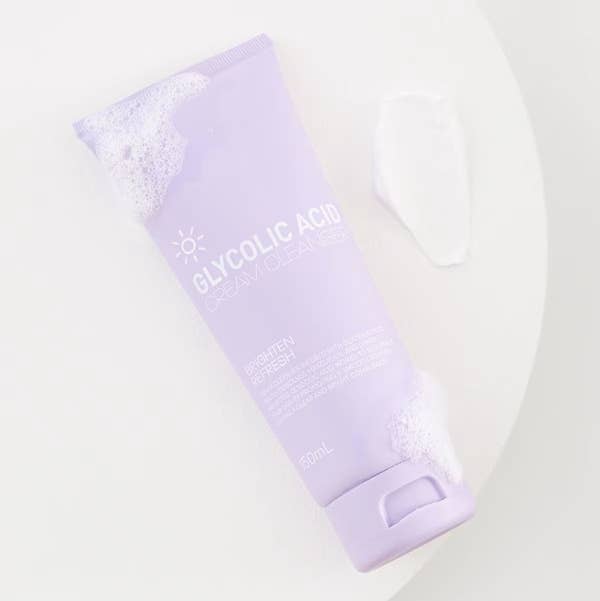 Glycolic Acid Cream Cleanser tube on a light surface with a dollop of cleanser next to it. Text reads: &quot;Brighten and Refresh.&quot;