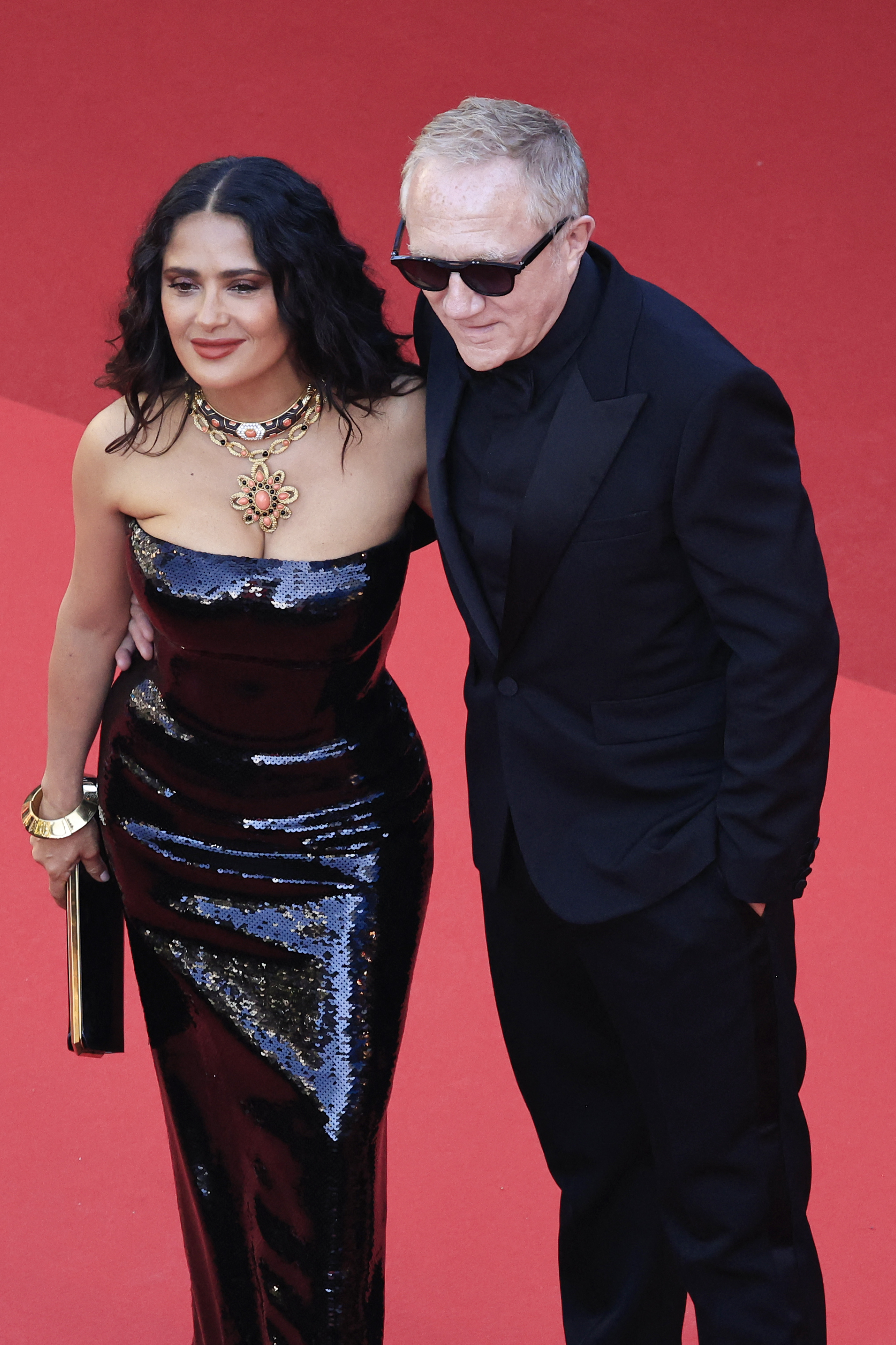 Salma Hayek in a strapless black sequined gown and François-Henri Pinault in a black tuxedo on a red carpet