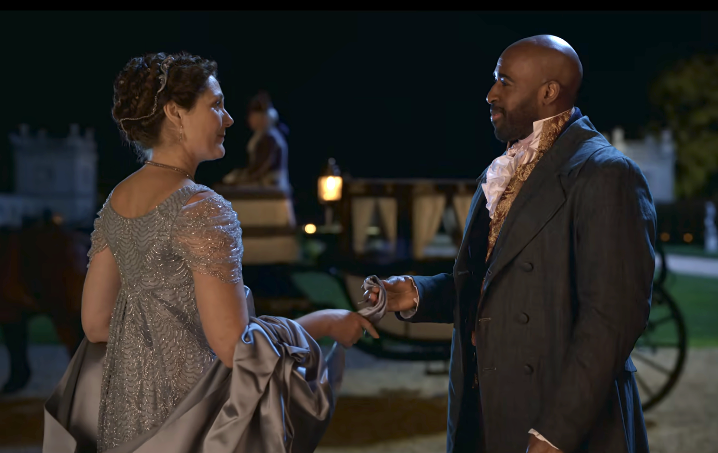 Ruth Gemmell and Daniel Francis in a period drama scene, dressed in vintage attire, with a horse-drawn carriage in the background at night