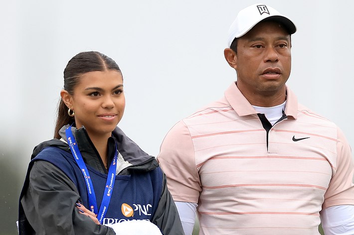 Two individuals, likely a father and daughter, standing side by side on a golf course