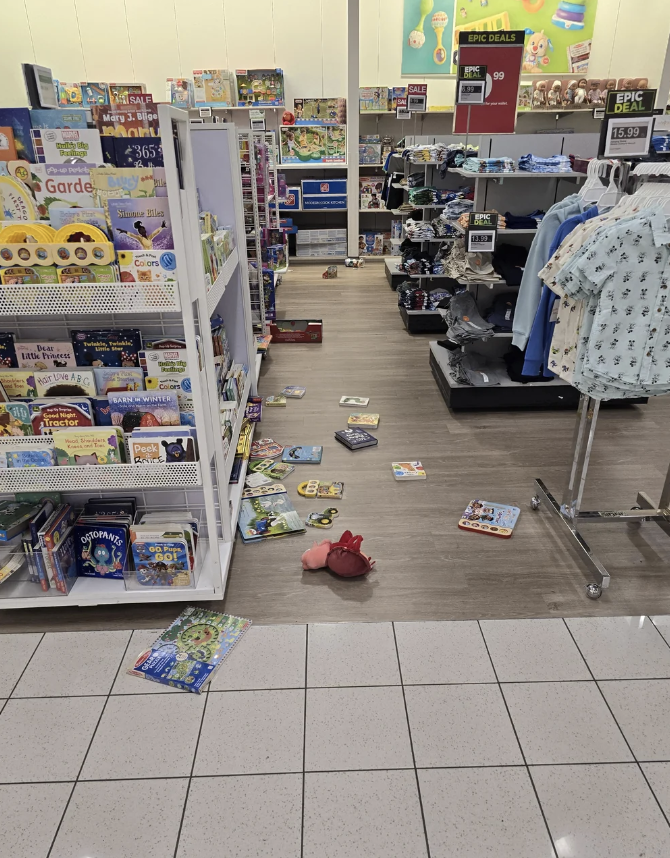 Toys and clothes scattered on the floor in a disorganized retail store aisle