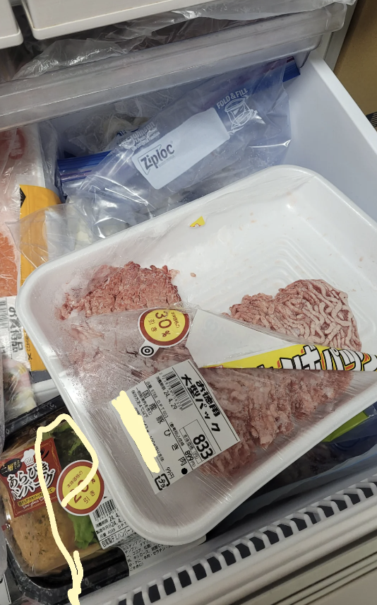 Freezer with open packages of ground meat and other assorted items
