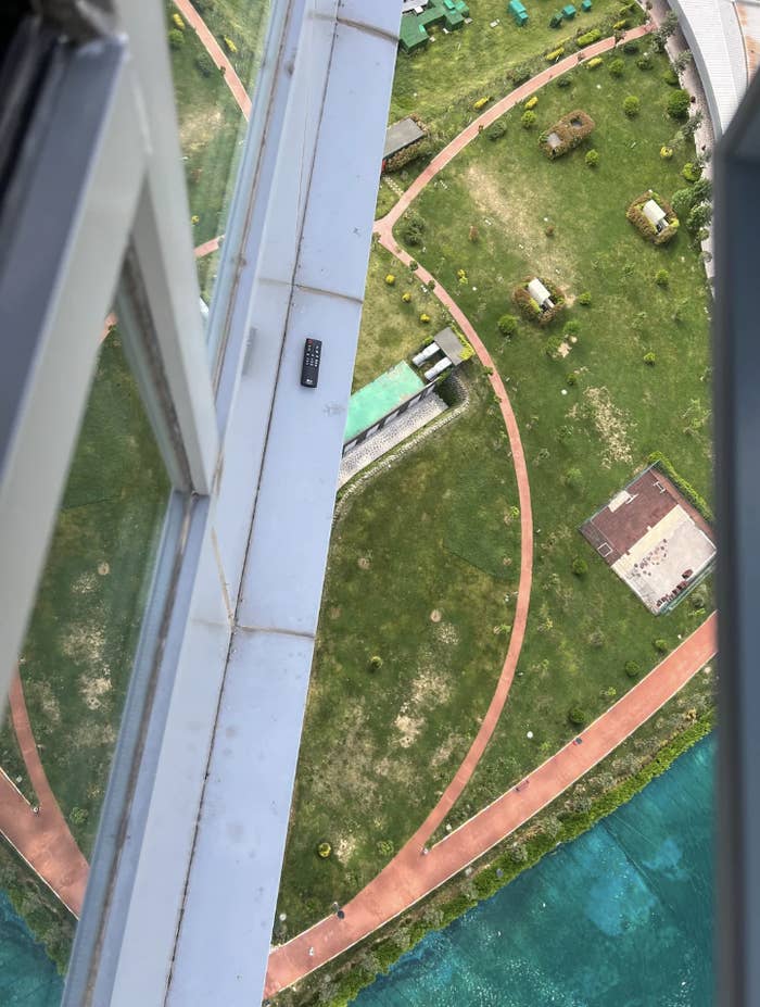 View from above showing a misplaced remote control on a building ledge overlooking a park