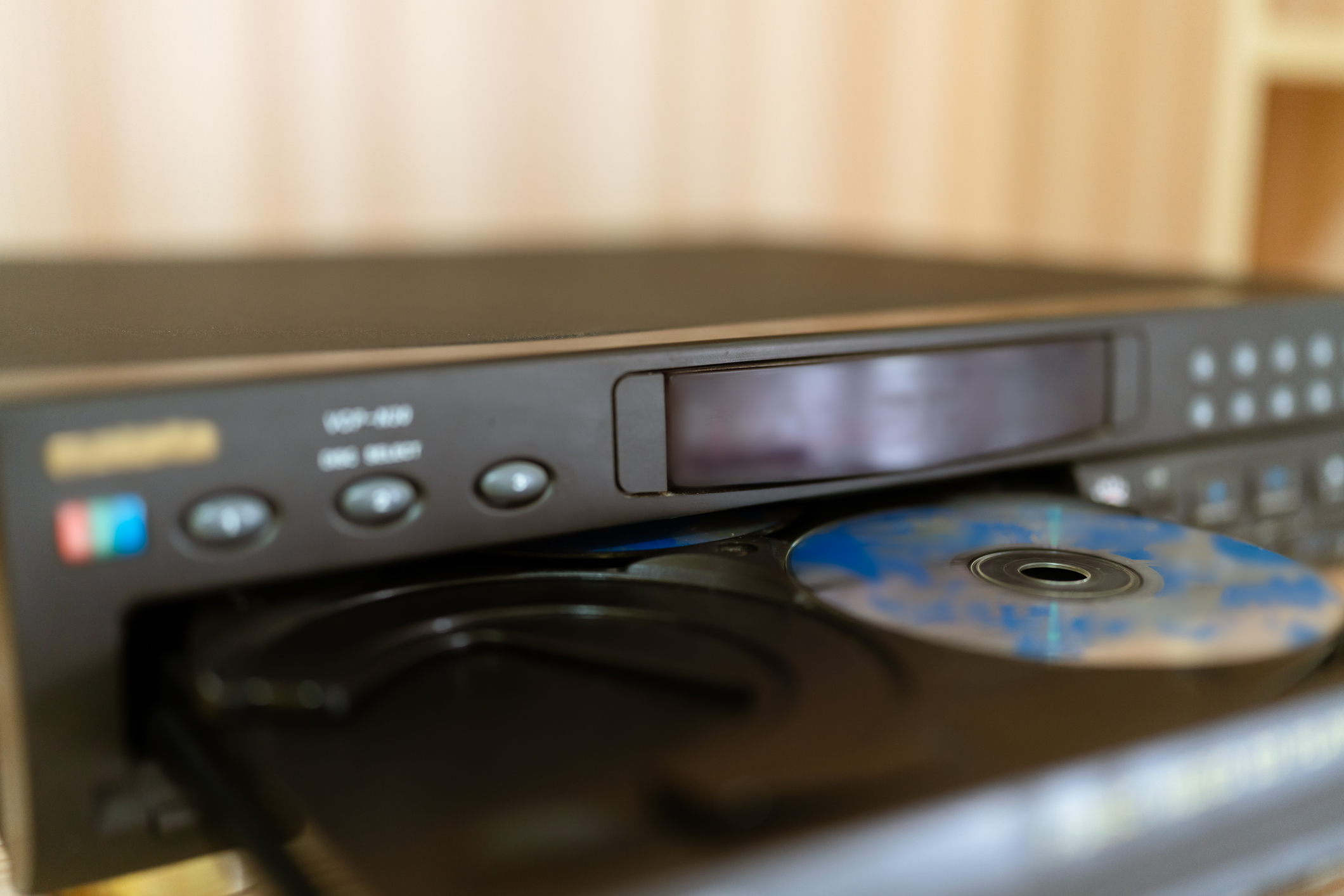 A DVD player with an open tray and disc partially inserted
