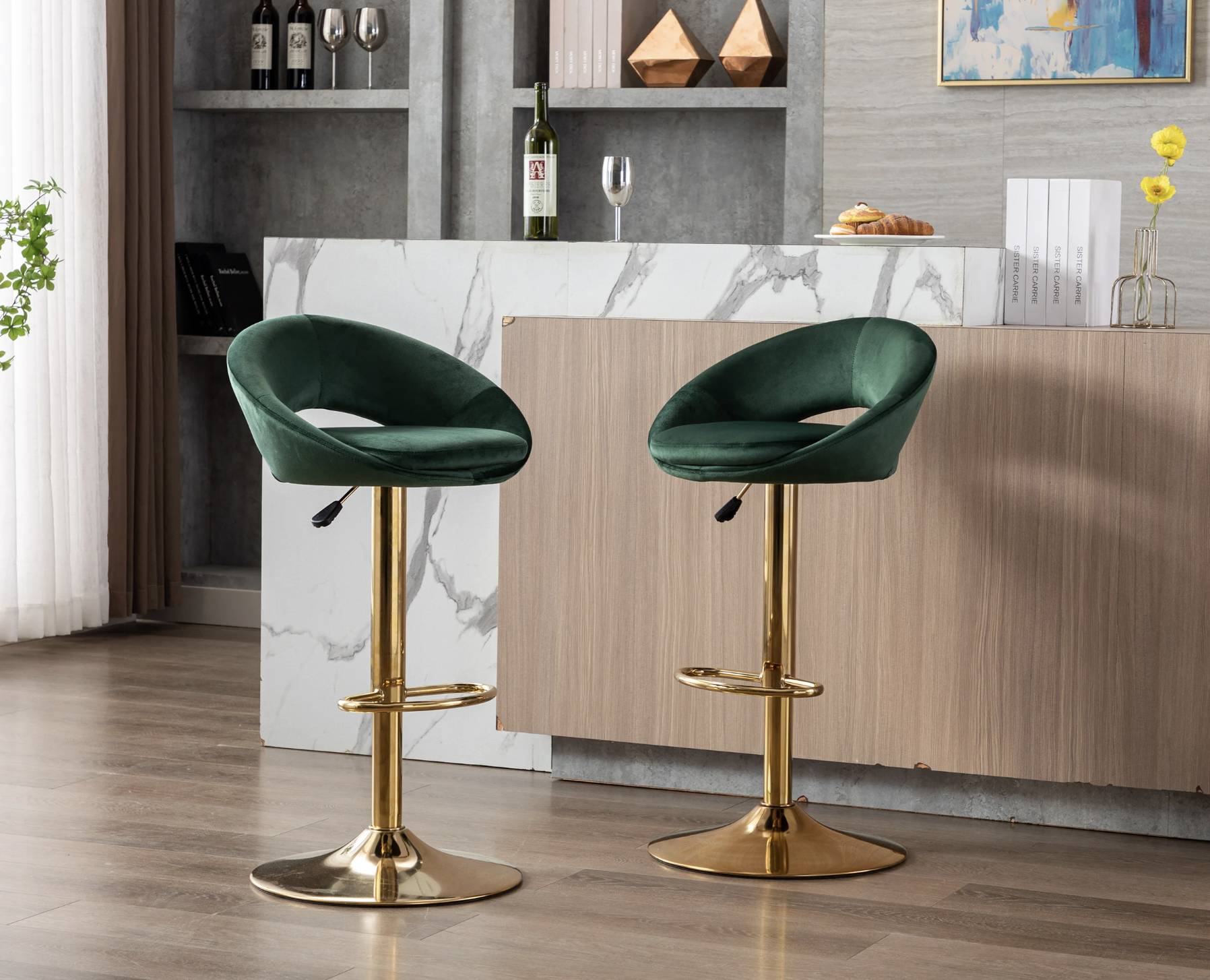 Two modern green velvet bar stools with gold bases in a kitchen