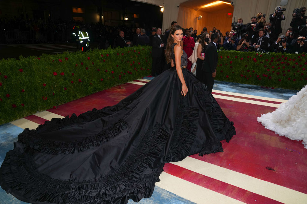 Kendall in an extravagant gown with voluminous skirt on the red carpet, photographers in the background