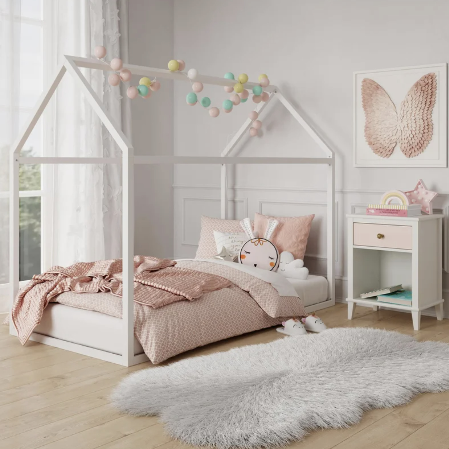 Child&#x27;s bedroom featuring a house-shaped bed frame with cozy bedding and a fluffy area rug