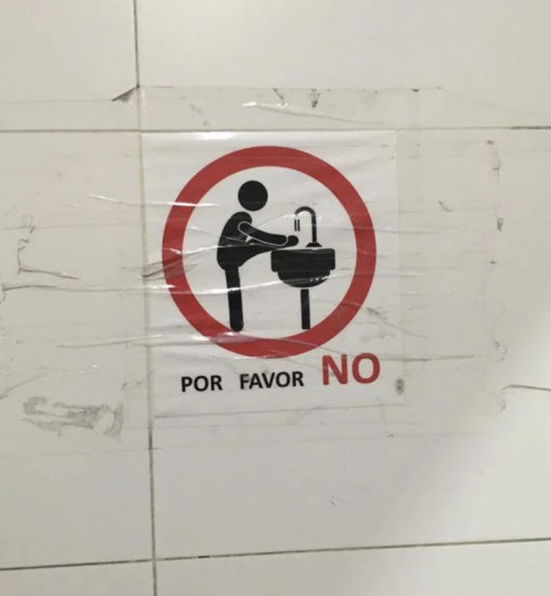 A sing showing a person washing their feet in the sink, with a circle and line going through it and the text por favor NO
