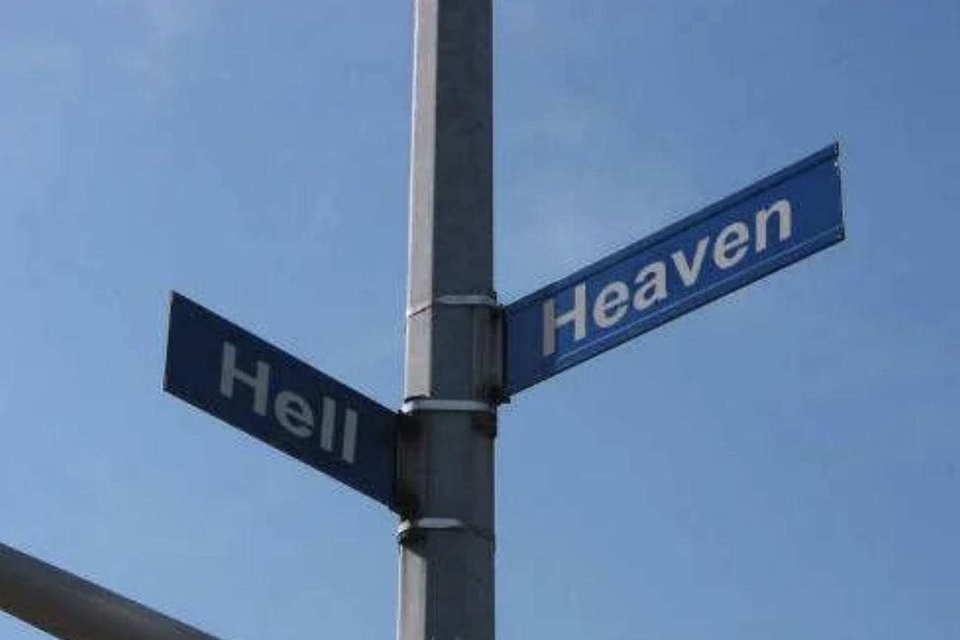 Street signs at an intersection labeled &quot;Heaven&quot; and &quot;Hell&quot; against a clear sky