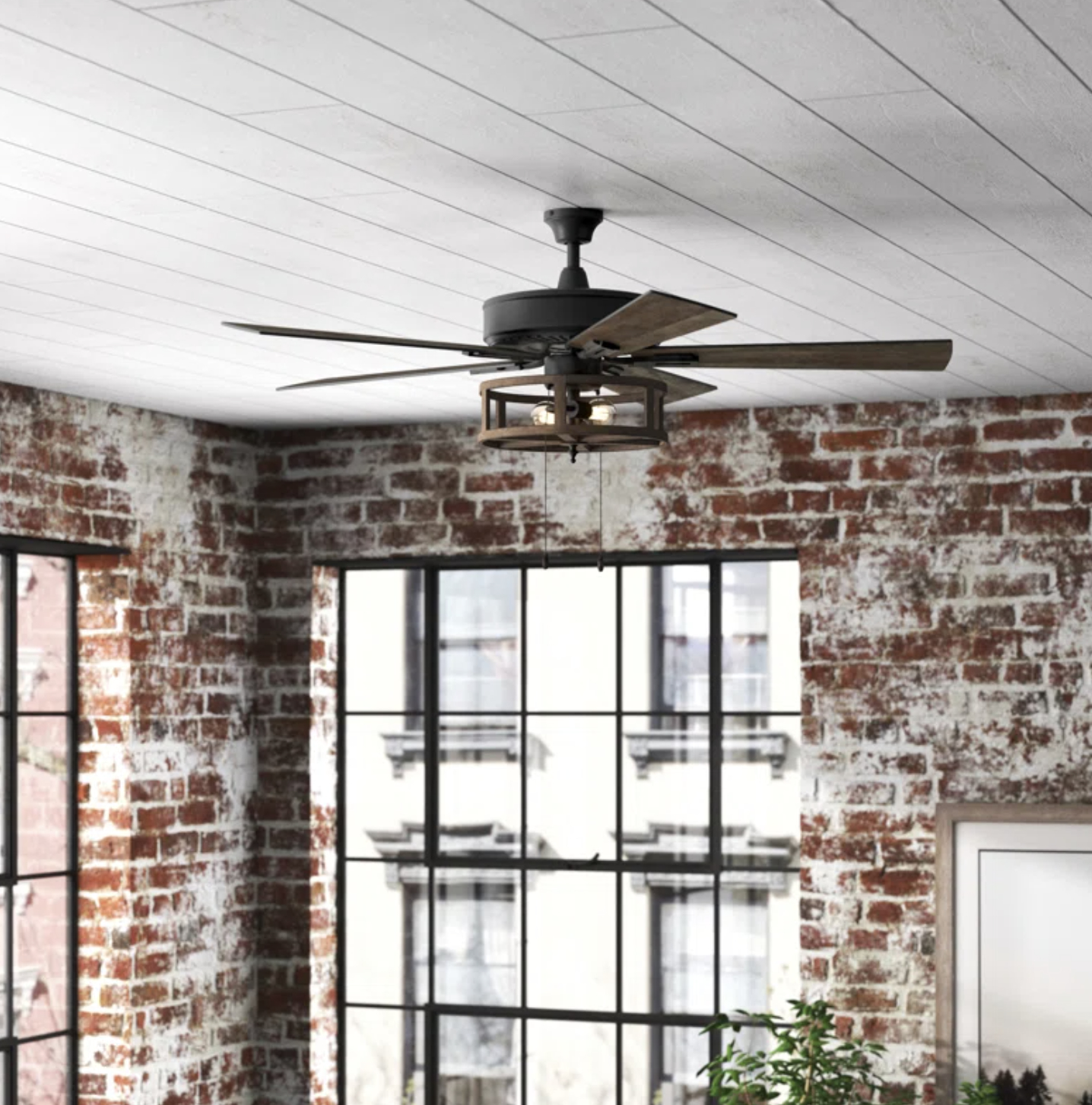 The ceiling fan with lights mounted in a room with a brick wall and large windows